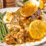 Lemon Chicken on plate with gravy being dripped over the top.