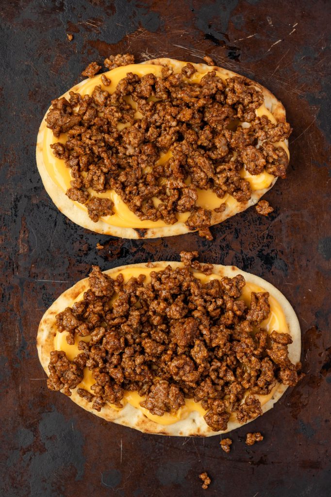 taco meat and nacho cheese on a naan.