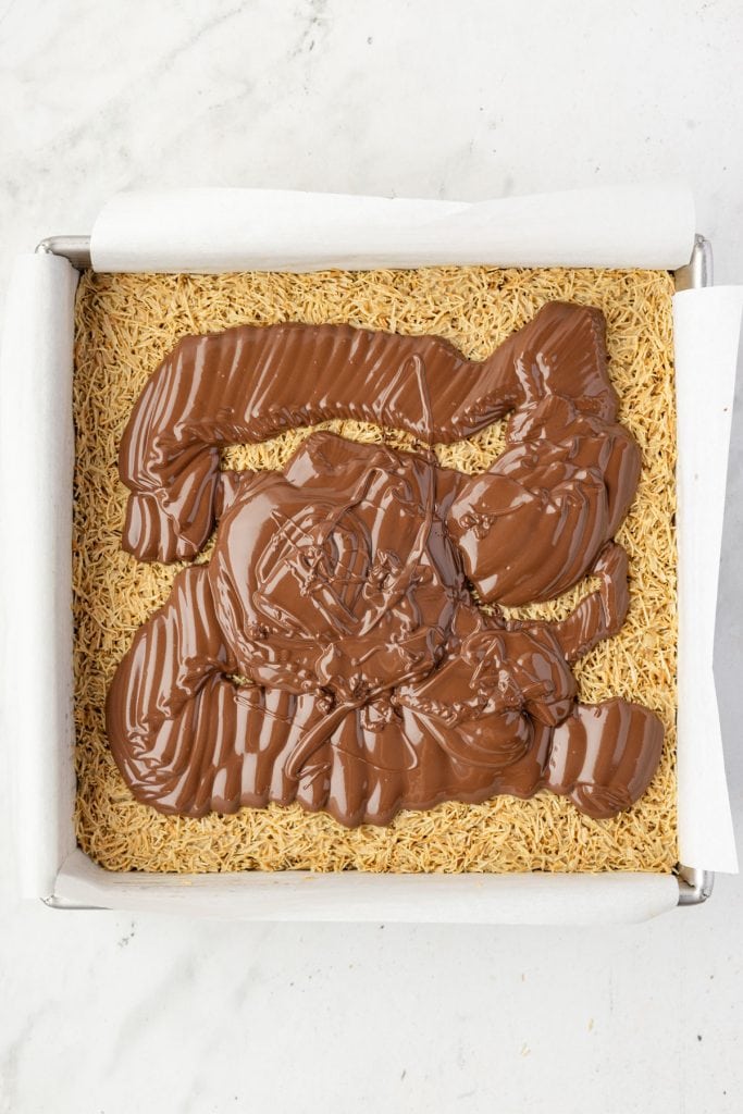 Pouring chocolate over brownies
