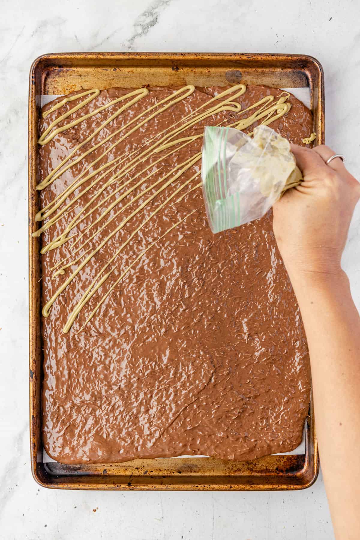 Drizzling pistachio butter over the chocolate.