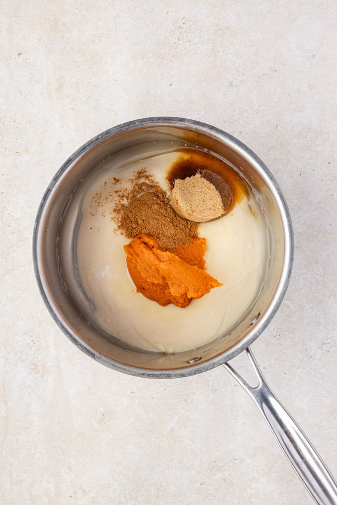 Condensed milk, water, pumpkin purée, pumpkin spice, brown sugar in a pot.
