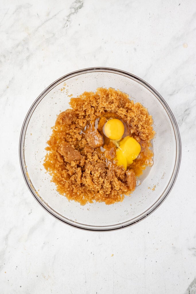 sugar and brown buter and eggs in a mixing bowl.
