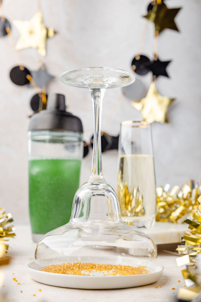 Margarita glass being dipped into core sugar for a champagne margarita