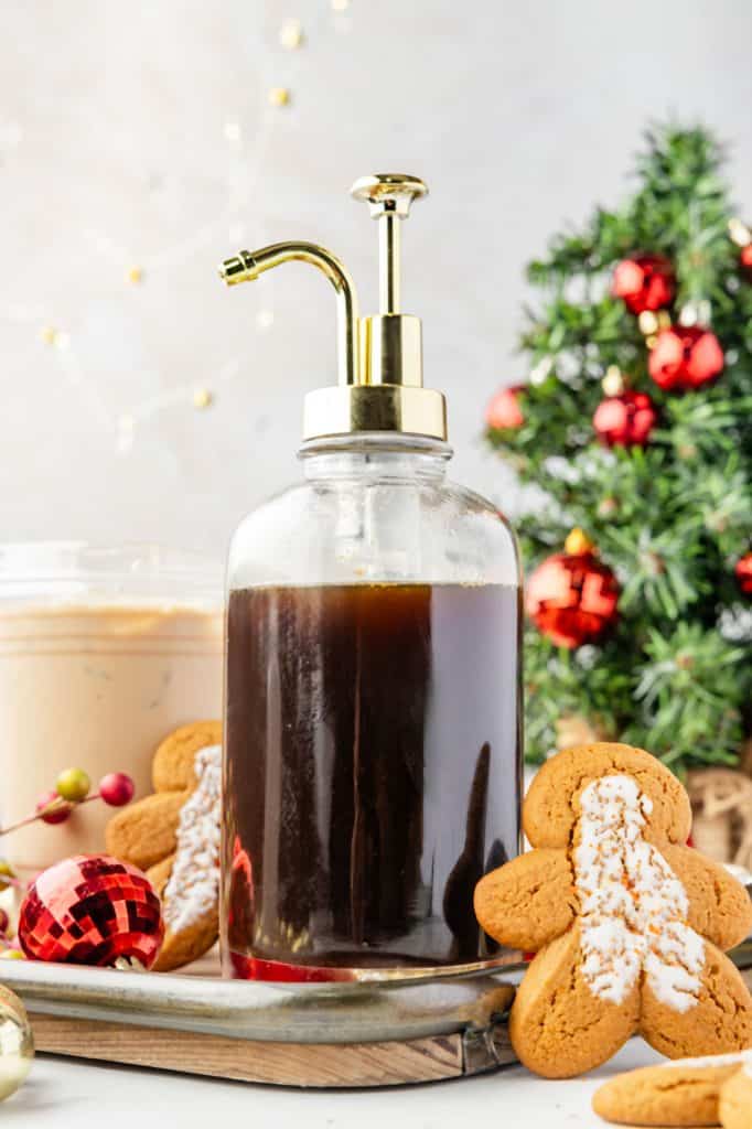 Gingerbread Simple SyrupWeb008 Gingerbread Simple Syrup in a container with a latte and Christmas decorations