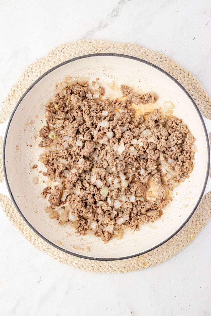 Ground beef, onions, garlic in a skillet.