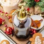 Gingerbread Simple Syrup in a container with a latte and Christmas decorations