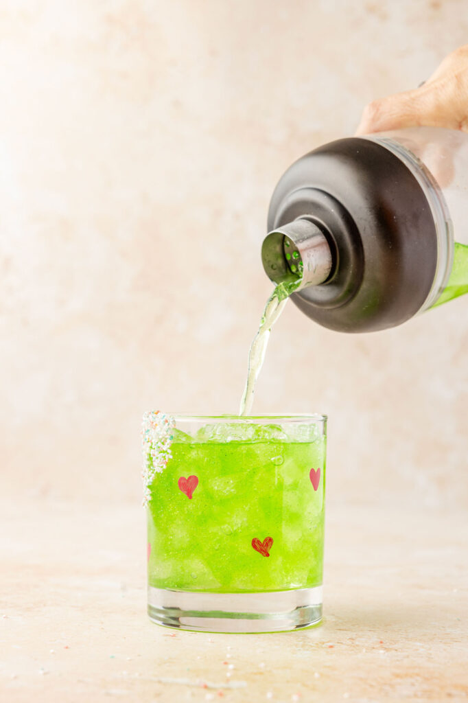 Pouring grinch margarita into glass
