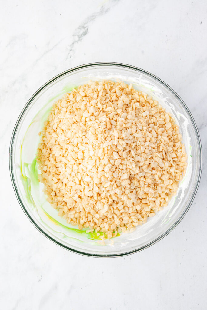 Melted marshmallow and rice crispies in a large mixing bowl