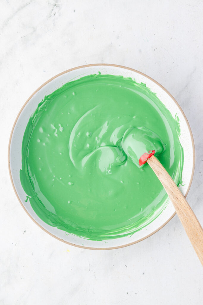 Melted green chocolate in a mixing bowl