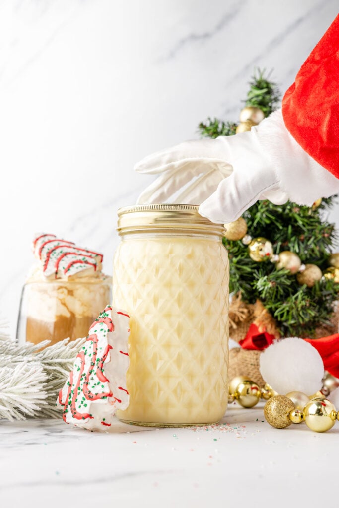 Santa arm grabbing a mason jar of Little Debbie Christmas Tree Coffee Creamer