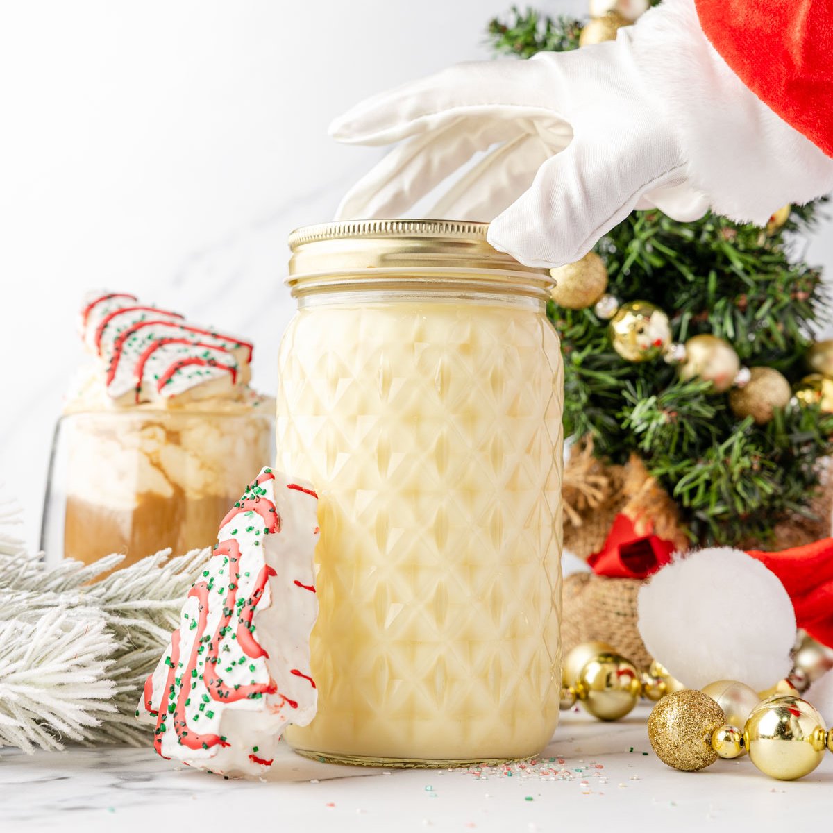 Santa arm grabbing a mason jar of Little Debbie Christmas Tree Coffee Creamer