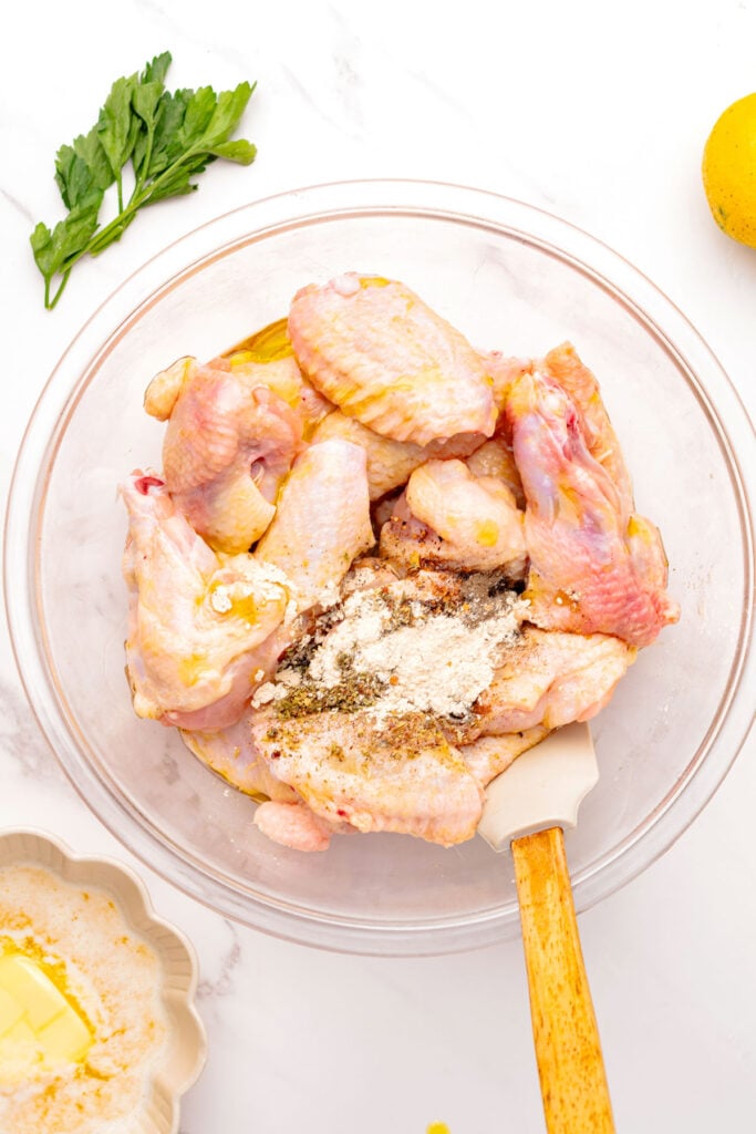 Chicken, wings, and spices and baking soda in a mixing bowl