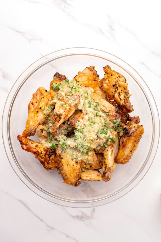 Undressed chicken wings topped with garlic Parmesan sauce