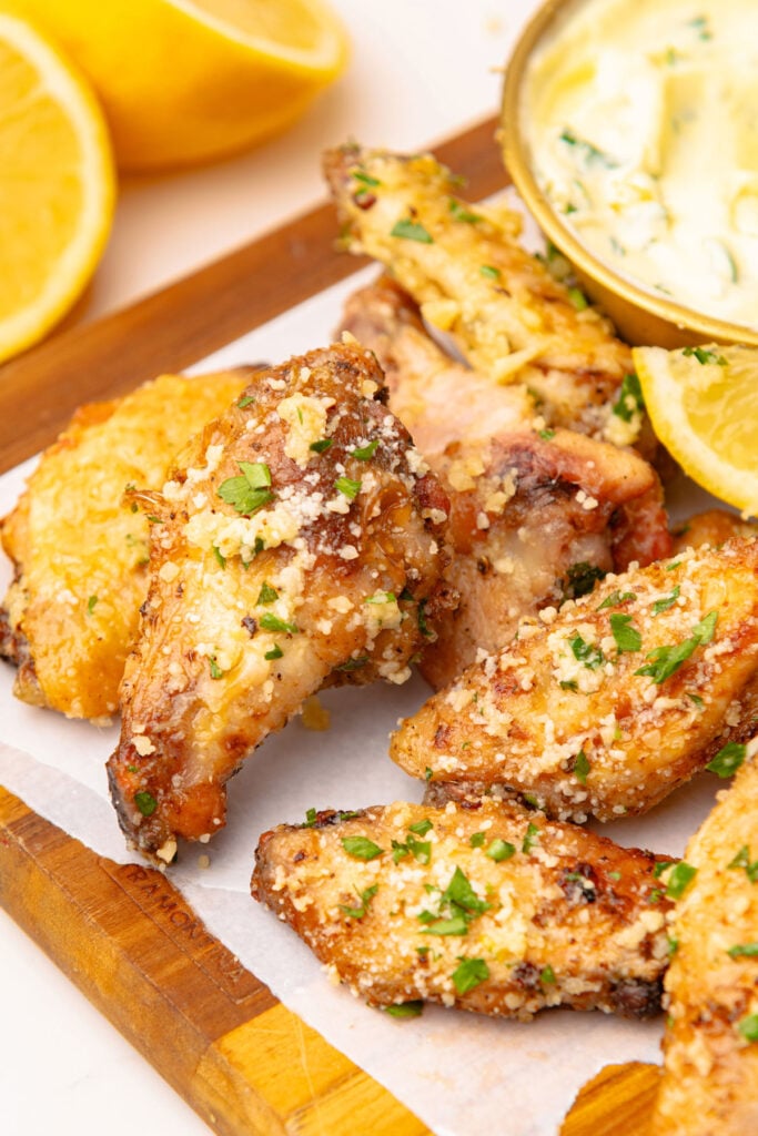 Air Fryer Garlic Parmesan Wings on a cutting board with garlic dip