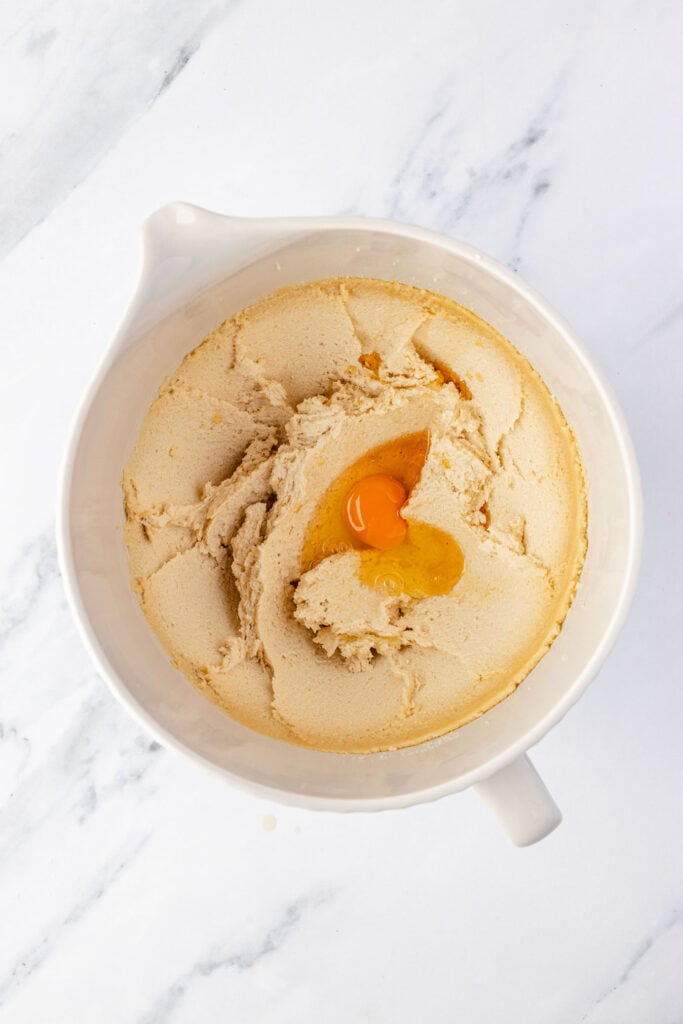 Butter mixture with eggs and vanilla in a mixing bowl.