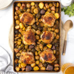 Sheet pan, chicken thighs cooked out of the oven with roasted brussels sprouts and potatoes