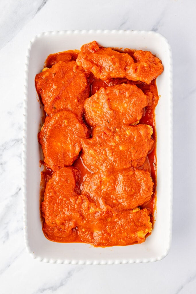 Sauce on top of chicken strips in a casserole pan