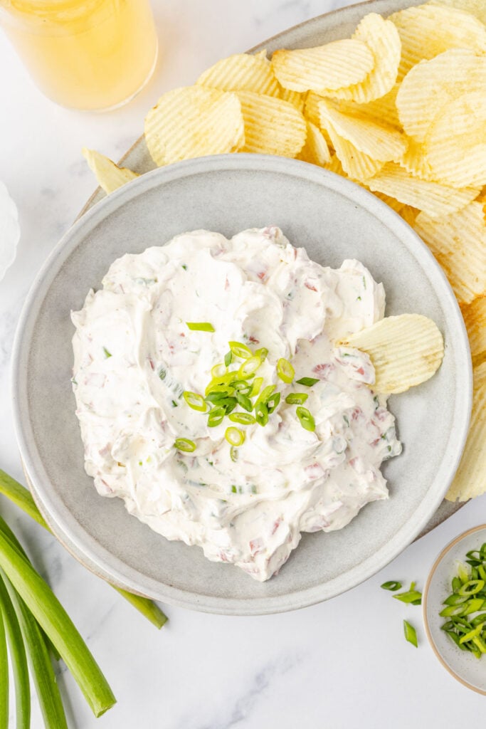 Chipped Beef Dip in a bowl on a platter with potato chips