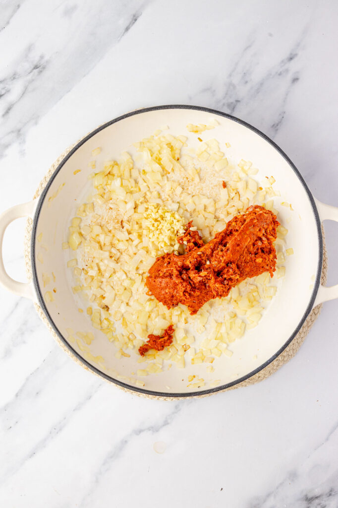 Cooked onions in a pan with raw chorizo