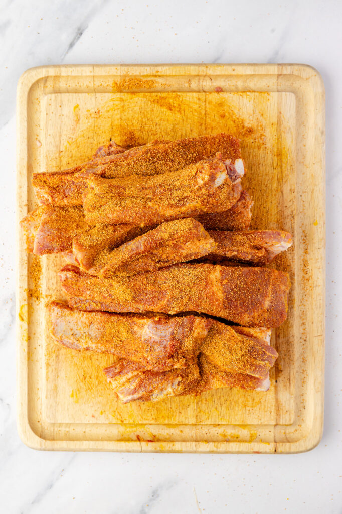 ribs covered in a spice rub on a cutting board