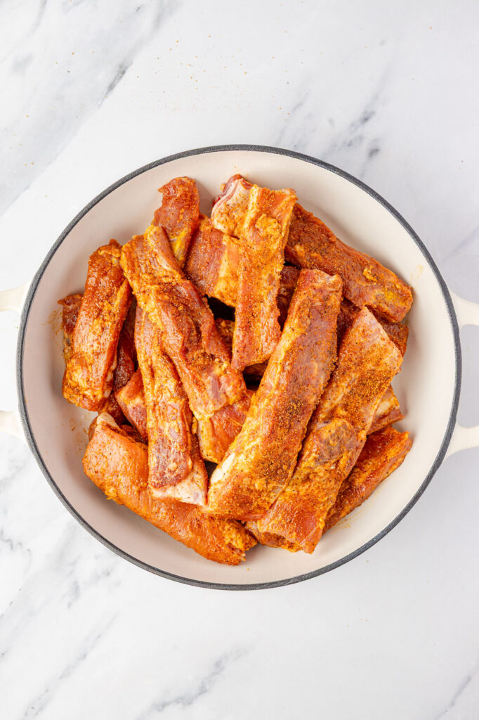 Ribs covered in rub in a pan