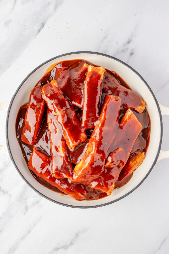Braised Pork Ribs in a pan with bbq sauce
