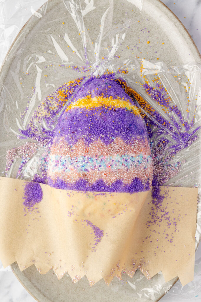 Parchment paper covering up a layer of the Easter cheesecake also so you can arrange the sprinkles.