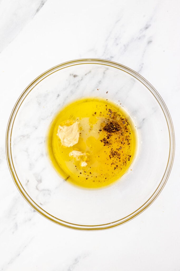 Lemon juice, oil, Dijon, mustard, apple cider vinegar, honey, salt, and pepper in a mixing bowl