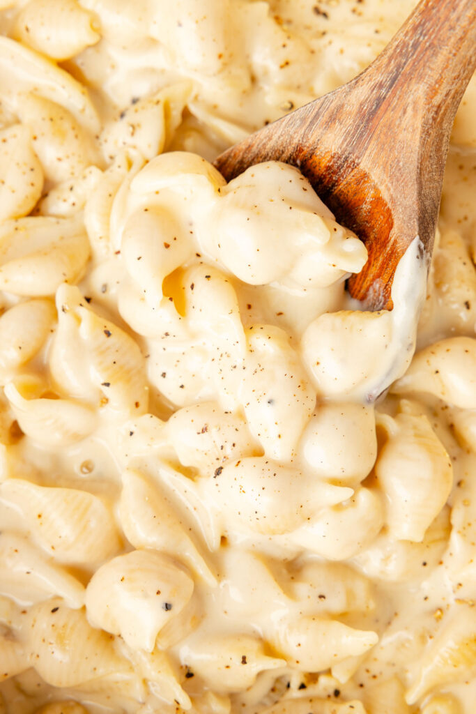 Close-up of Gouda mac & cheese with a wooden spoon scooping