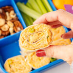 Hand picking up a buffalo chicken pinwheel