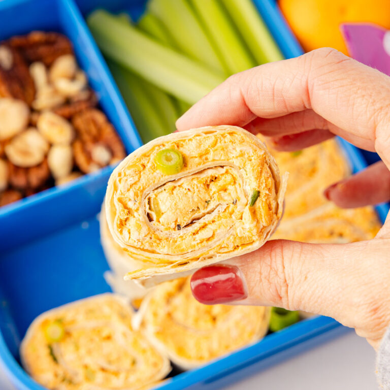 Hand picking up a buffalo chicken pinwheel