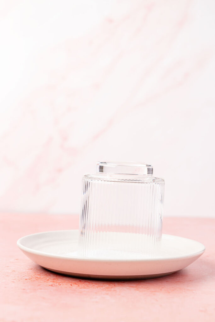 Plate of salt with a glass being dipped into it.