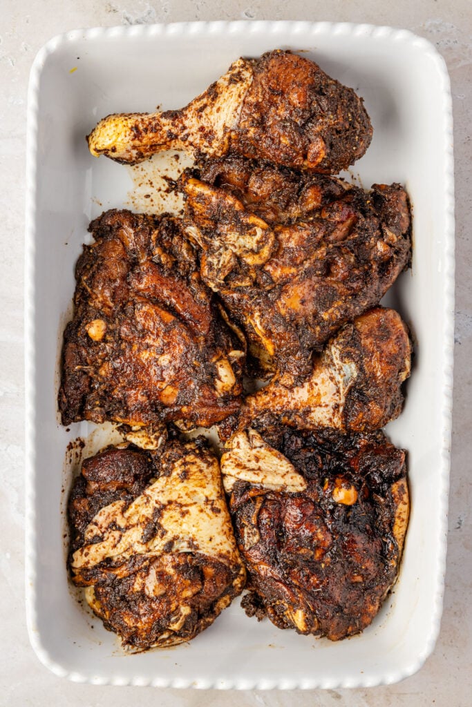 Raw Close-up of baked jerk chicken in a casserole pan