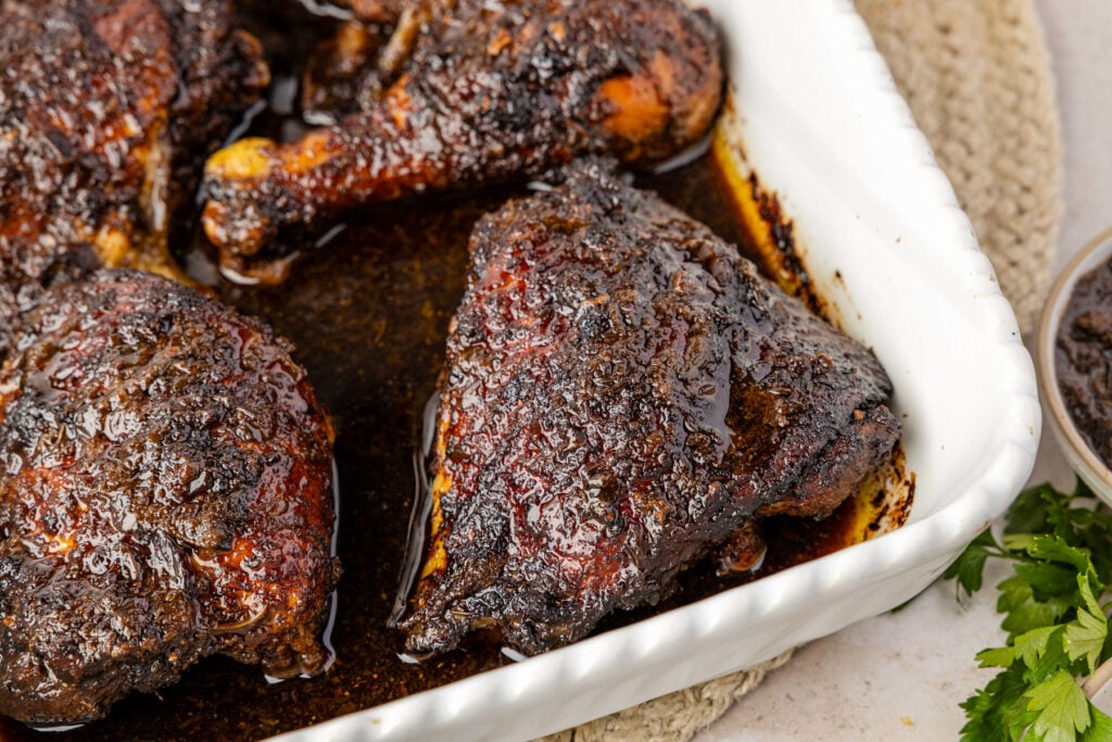 Close-up of baked jerk chicken in a casserole pan