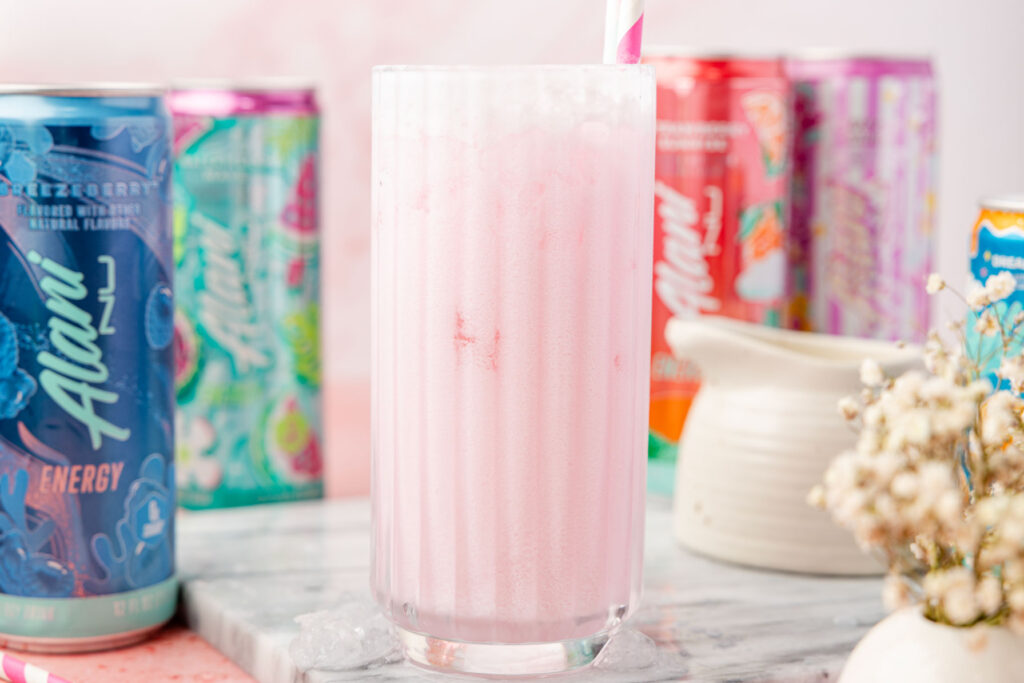 DIRTY ALANI IN A CUP WITH CANS OF ALANI AROUND IT AND A OF COFFEE CREAMER