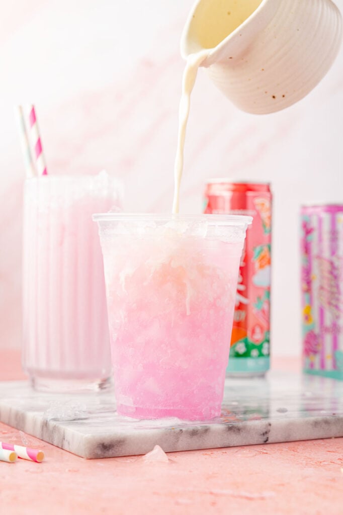 DIRTY ALANI IN A CUP WITH CANS OF ALANI AROUND IT AND A OF COFFEE CREAMER