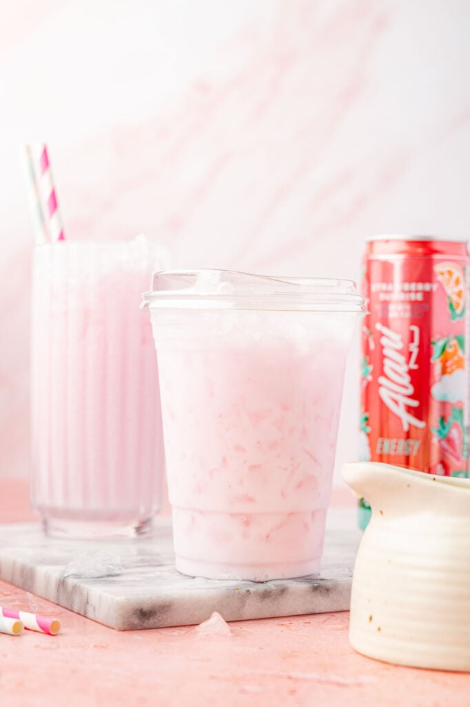 DIRTY ALANI IN A CUP WITH CANS OF ALANI AROUND IT AND A OF COFFEE CREAMER