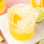 Virgin Margarita (Margarita Mocktail) in a glass with limea and oranges around it.
