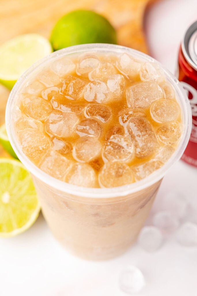 Dirty Dr Pepper in a cup with limes and a can of the dr pepper