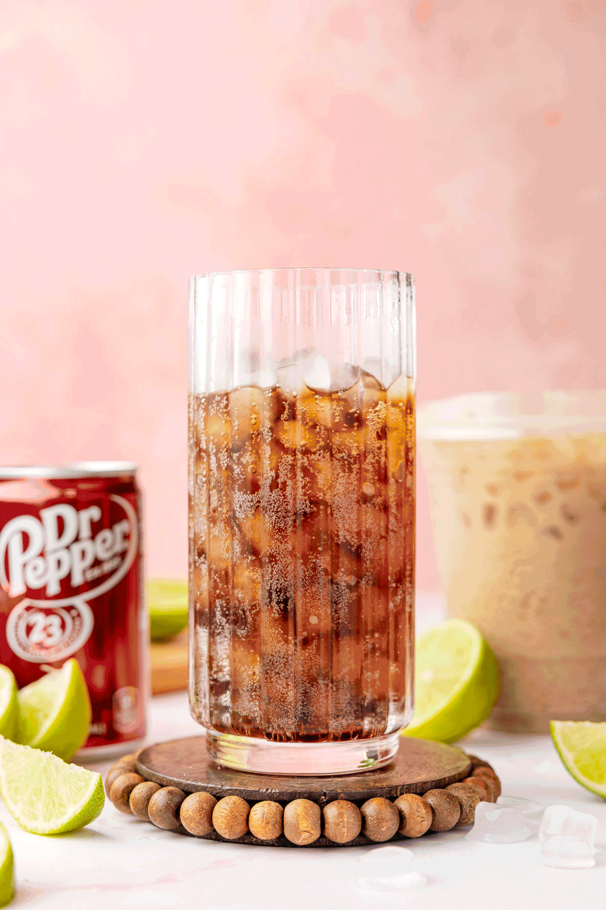 Dr Pepper in a glass with limes and a can of the dr pepper