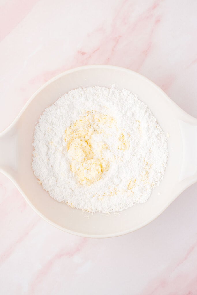 Powdered sugar and country cock in a mixing bowl