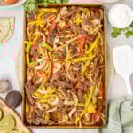 Sheet pan steak fajitas with ingredients to make fajitas around the sheet pan