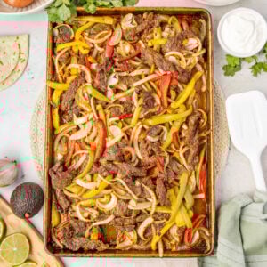 Sheet pan steak fajitas with ingredients to make fajitas around the sheet pan