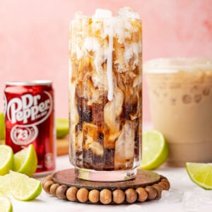 Dirty Dr Pepper in a glass with limes and a can of the dr pepper