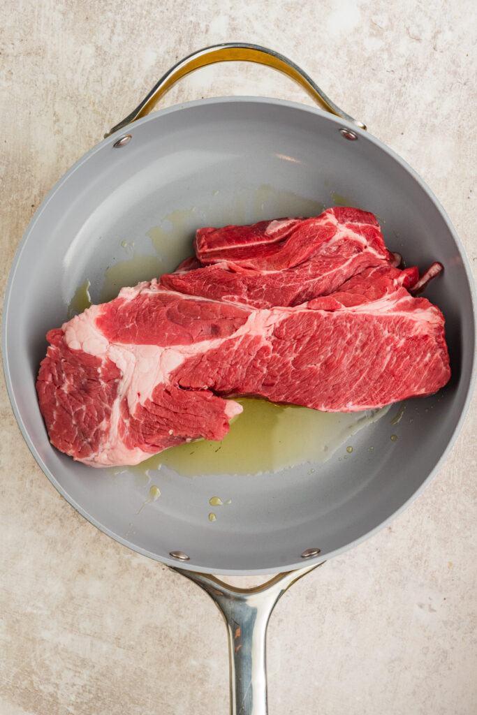 Chuck roast in a skillet with oil