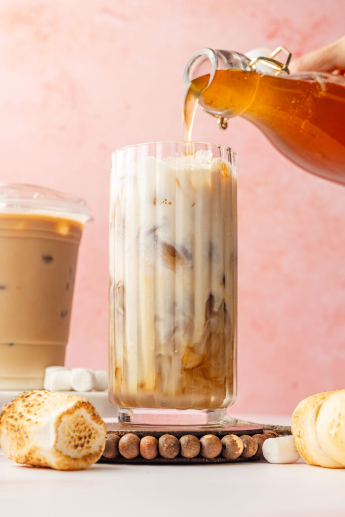 Pouring Toasted Marshmallow Syrup into an iced coffee