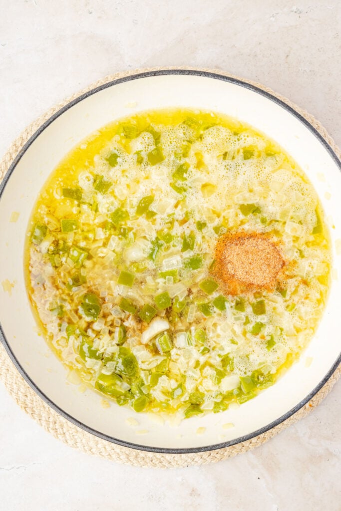 Butter sauce with spices, onions, garlic, and green bell pepper i n a pan