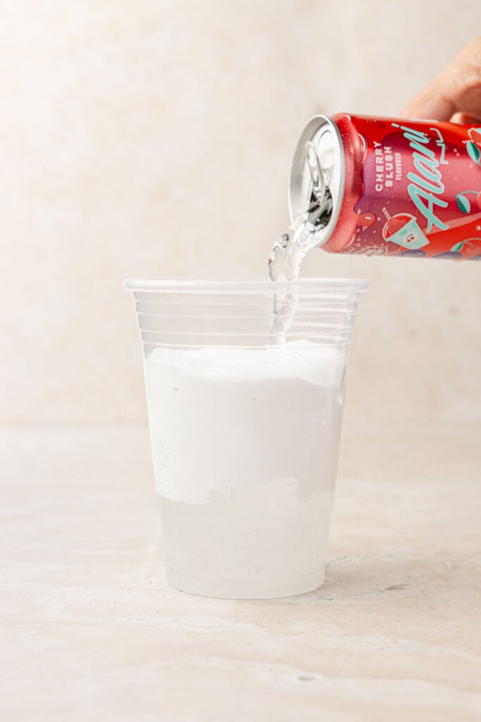 Alani being poured into a cup with marshmallow fluff spread inside.