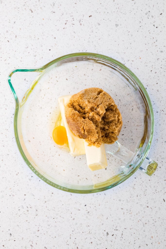 Brown sugar, butter, and an egg in a mixing bowl
