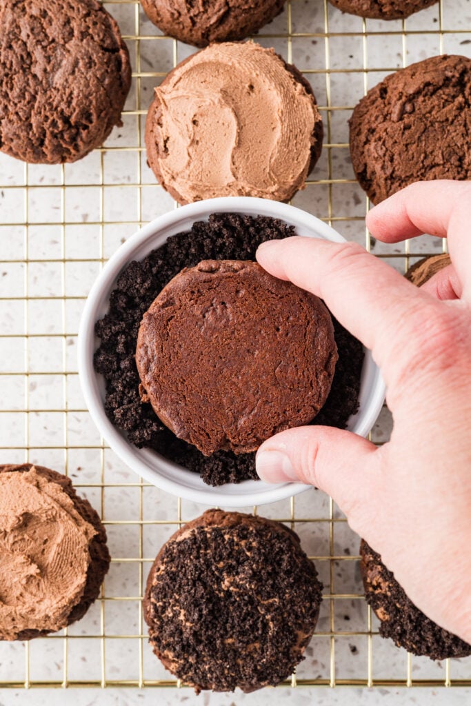Dipping a dirt cake cookie into Oreo crumbs